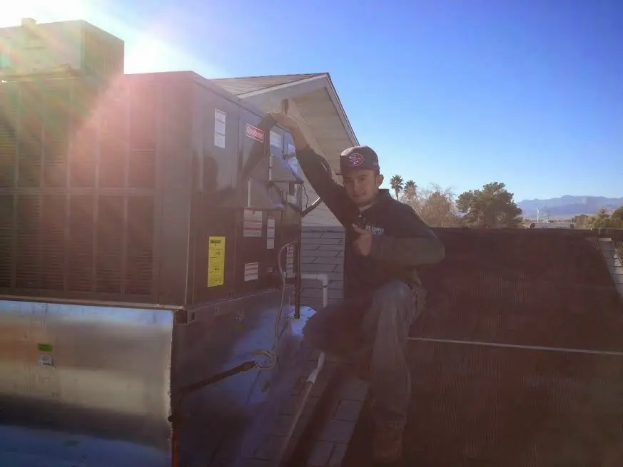 HVAC technician performing HVAC Inspection on a rooftop unit in Bagley